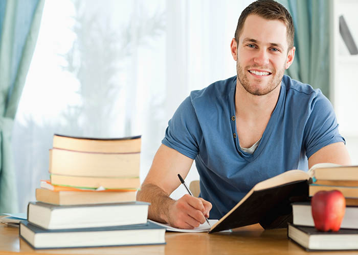 Smiling male student preparing for test